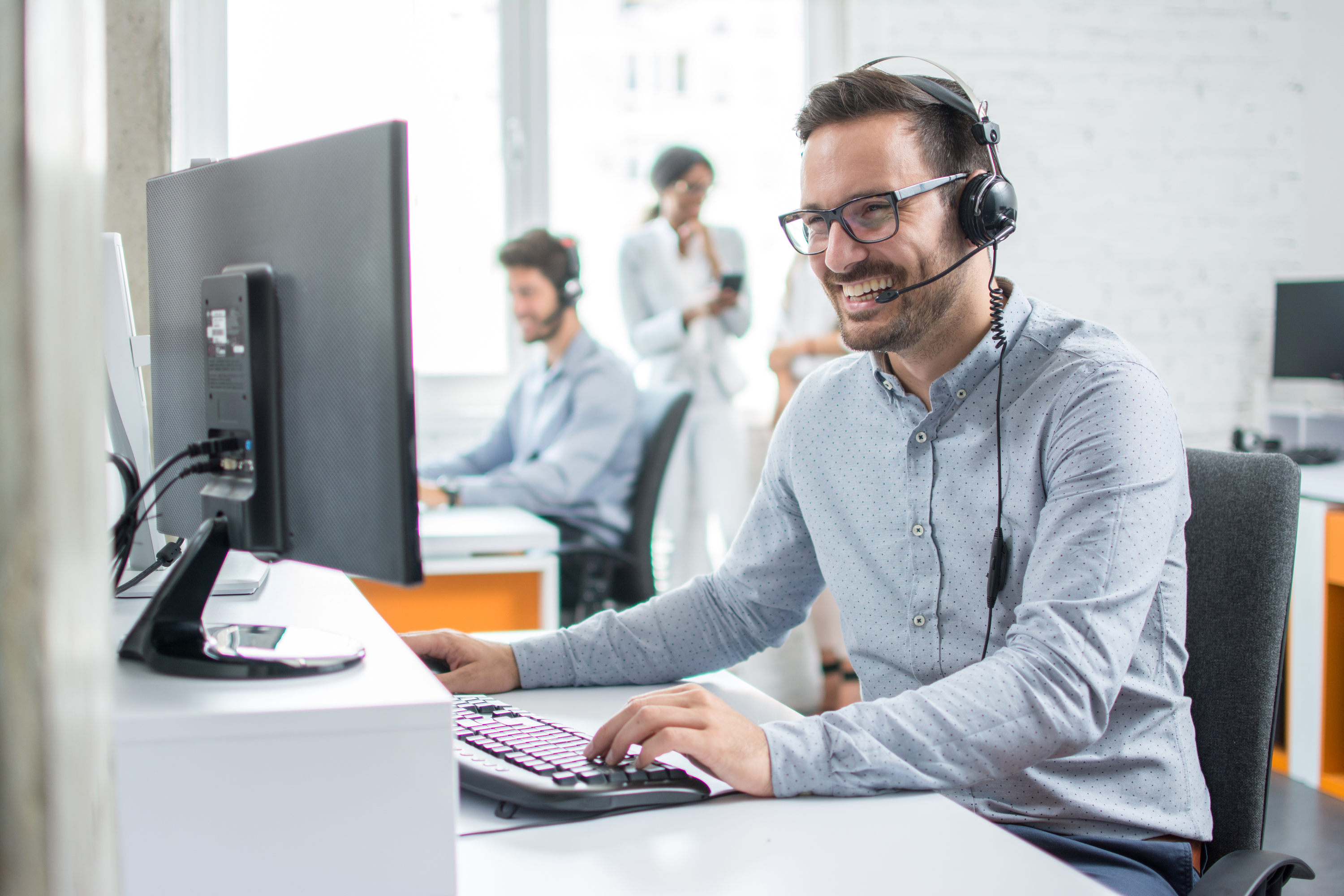 Lifestylebild lachender Mann mit Headset im Büro, CORE 